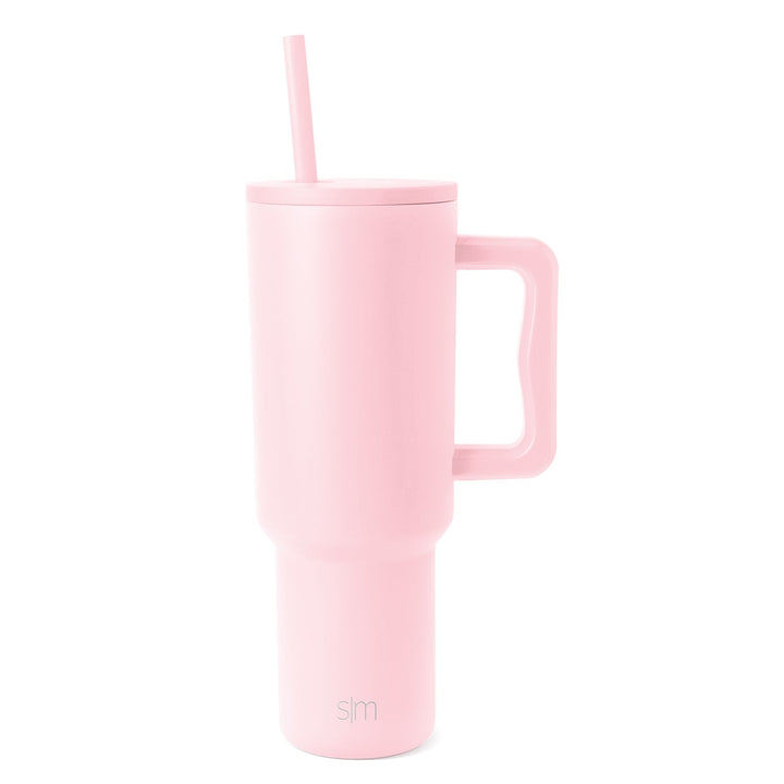 Pale pink insulated tumbler with wide handle, fitted lid and matching straw on white background. Simple Modern logo visible on body.